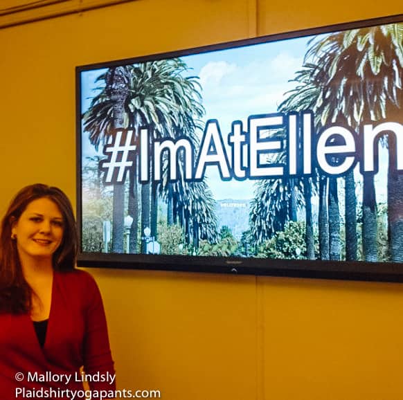 Mallory standing in front of a sign saying #Imatellen