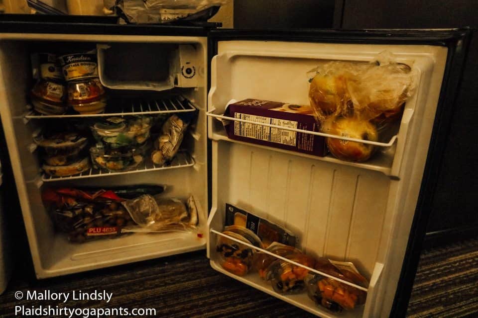 Small fridge with apples, salads, hummus and other healthy treats.
