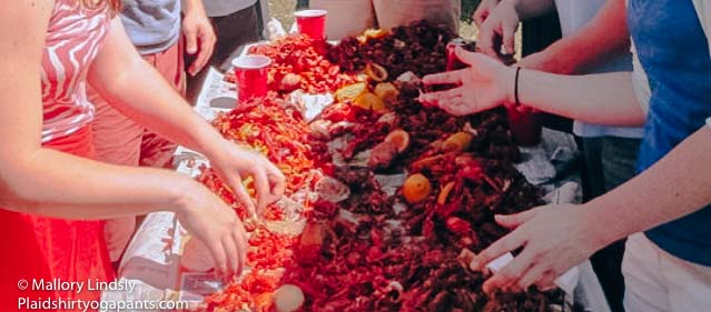A group of friends hanging out eating crawfish.