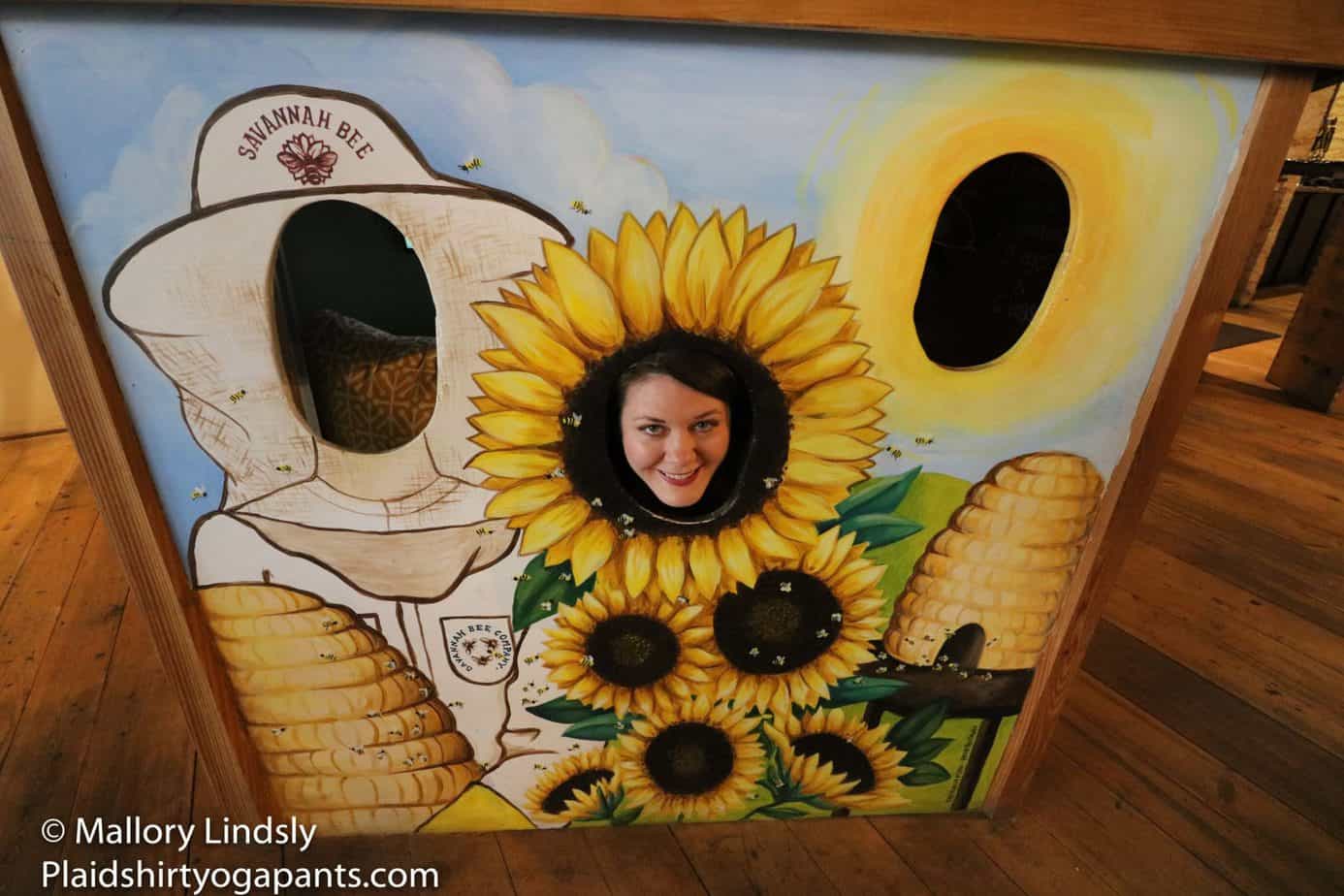 Mallory in a sunflower face cut out at Savannah Bee Company