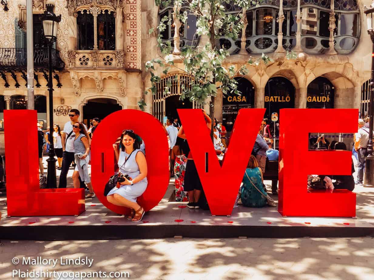 Mallory hanging out by Casa Batllo in a Love sign.