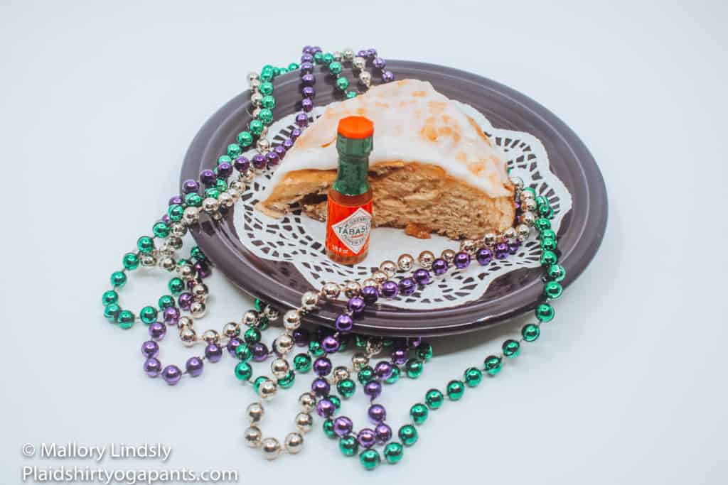 Sucre King Cake Sugar and Spice with miniature tabasco bottle. 