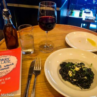 Solo Travel in New Orleans reading a book at dinner
