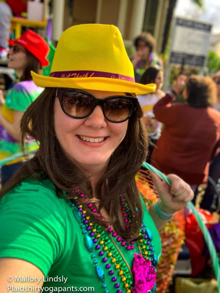 Girl with yellow hat and green shirt at a Mardi Gras Parade in New Orleans, Louisiana, surviving Mardi Gras
