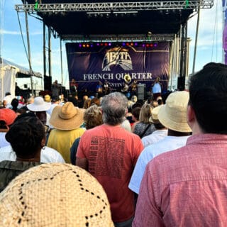 a crowd standing in front of the abita stage at french quarter fest